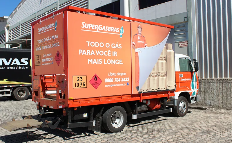 Caminhão da Supergasbrás visto de trás com painel de alumínio e lona