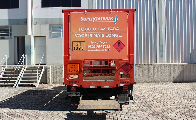 Traseira de caminhão da Supergasbrás com painel de lona e plataforma elevatória
