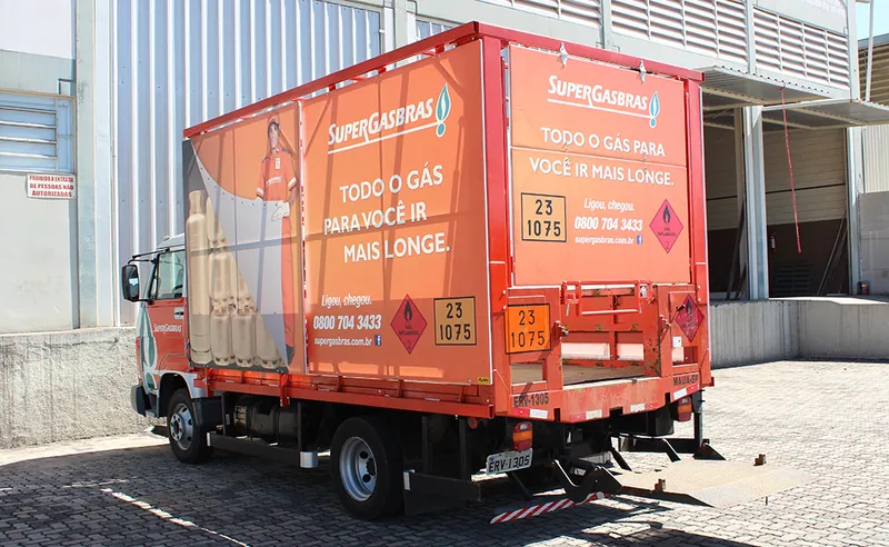 Lateral e traseira do caminhão da Supergasbrás com painel de lona impresso