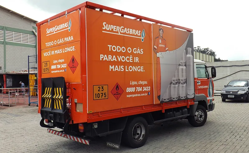 Caminhão da Supergasbrás com plataforma elevatória traseira e painel impresso