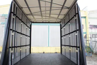 Interior de carroceria com cortinas laterais recolhidas e teto de lona